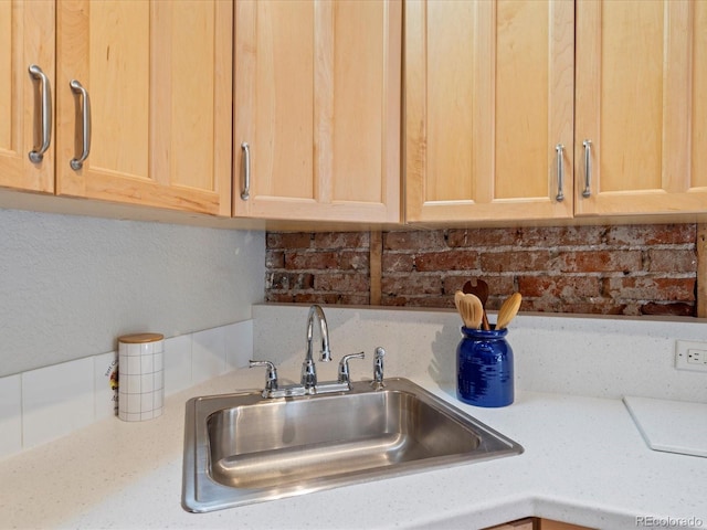 interior details featuring backsplash, sink, and light brown cabinets