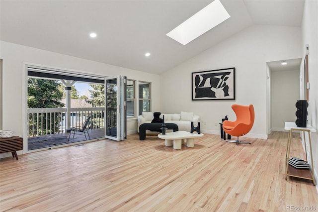 living area featuring baseboards, recessed lighting, a skylight, high vaulted ceiling, and wood finished floors