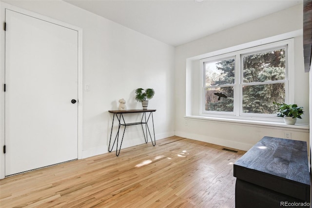 interior space with light wood-style floors, baseboards, and visible vents