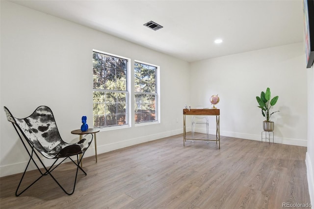 living area with light wood-type flooring, baseboards, and visible vents