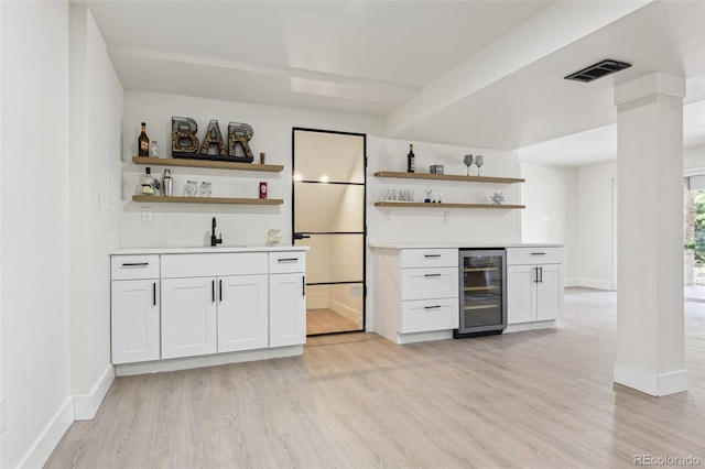 bar featuring a sink, visible vents, beverage cooler, and indoor wet bar