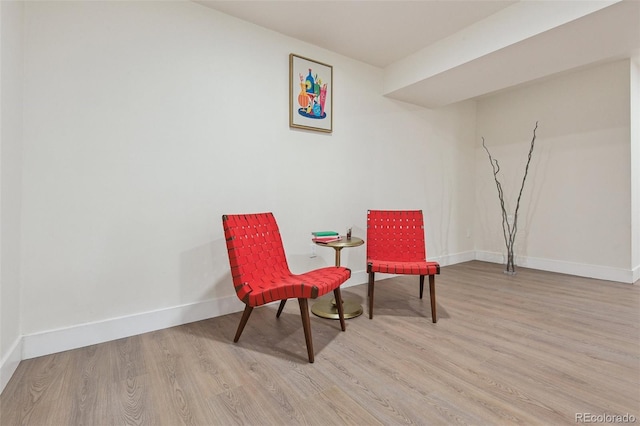 living area featuring baseboards and wood finished floors