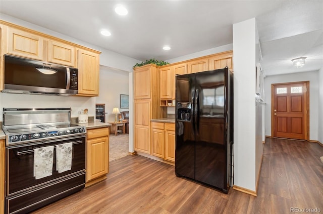 kitchen with dark hardwood / wood-style flooring, black fridge with ice dispenser, range with electric stovetop, and light brown cabinets