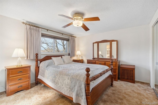 bedroom featuring ceiling fan, light carpet, and a textured ceiling