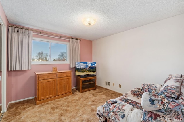 sitting room with light colored carpet and a textured ceiling