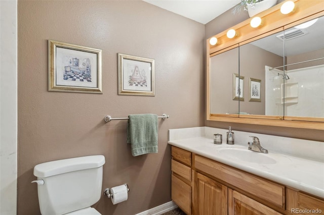 bathroom featuring vanity, toilet, and a shower