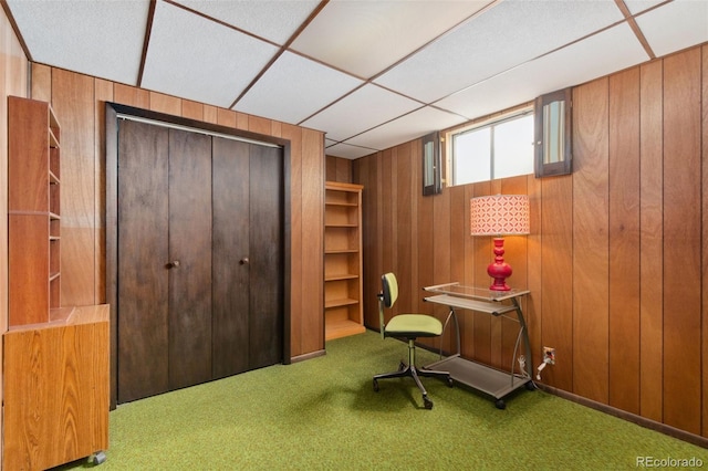 office with carpet flooring, a drop ceiling, and wood walls