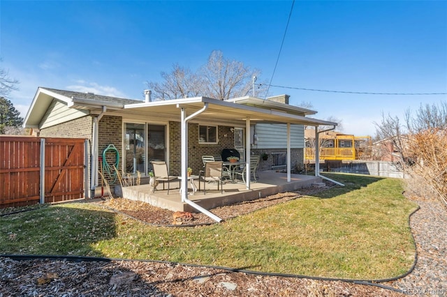 back of property with a lawn and a patio