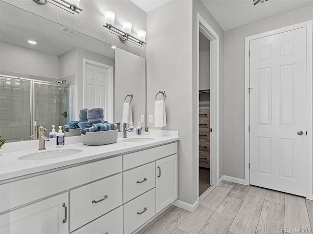 55 S Edge Cliff St, Castle Rock, CO 80104 - full bath with a stall shower, double vanity, wood finished floors, a spacious closet, and baseboards