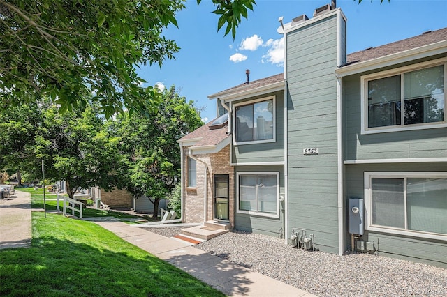 8753 W Cornell Ave Unit 12-1, Denver, CO 80227 - view of front of home with a chimney, a front yard, and a shingled roof