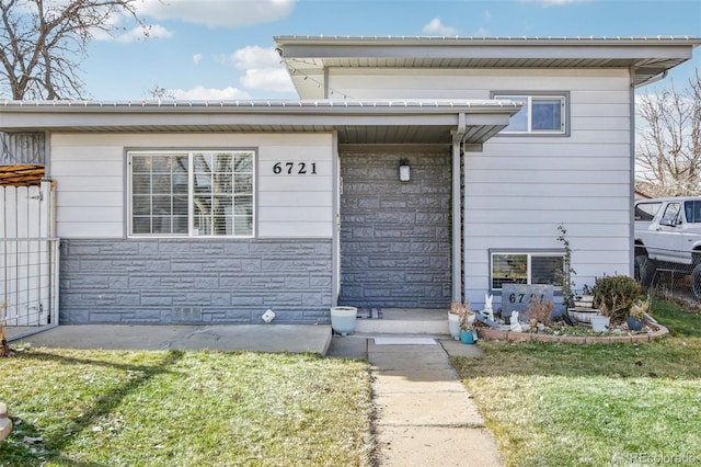 doorway to property with a lawn