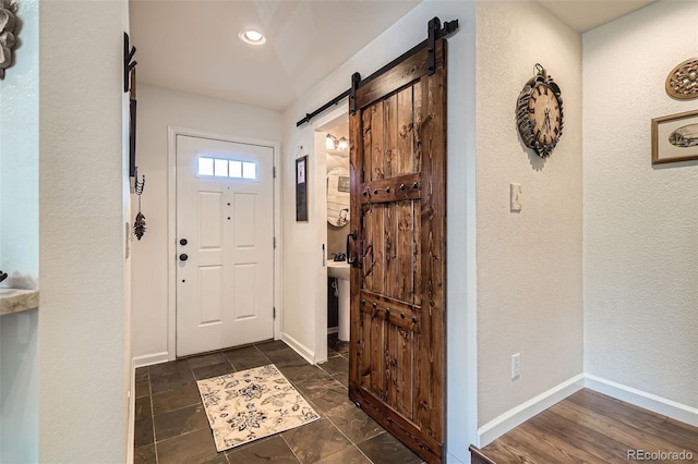 5843 Ceylon St, Denver, CO 80249 - entryway with a barn door, baseboards, and a textured wall