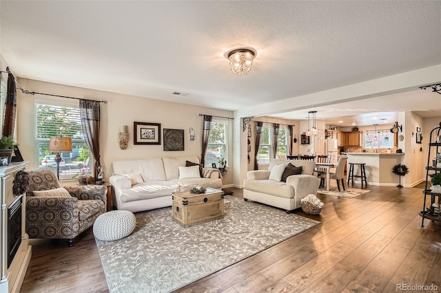 5843 Ceylon St, Denver, CO 80249 - living area with wood finished floors, baseboards, and a textured ceiling