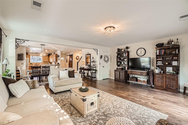 5843 Ceylon St, Denver, CO 80249 - living room with wood finished floors, a chandelier, and baseboards
