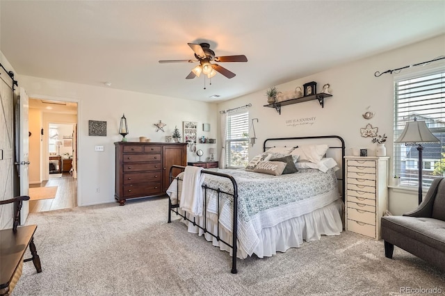 5843 Ceylon St, Denver, CO 80249 - bedroom featuring light carpet, ceiling fan, and a barn door