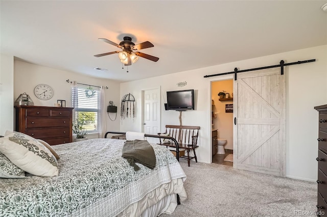 5843 Ceylon St, Denver, CO 80249 - carpeted bedroom featuring a barn door, baseboards, a ceiling fan, and ensuite bath