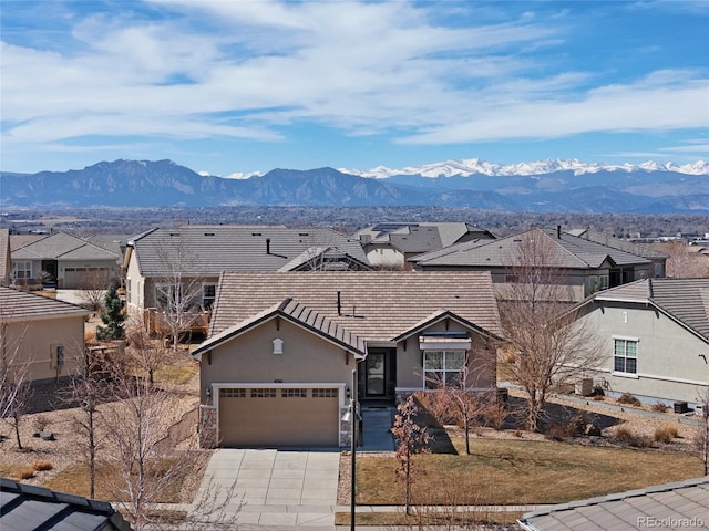 exterior space featuring a mountain view, stucco siding, driveway, and a garage