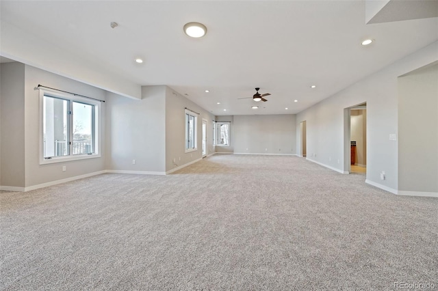 carpeted spare room with ceiling fan and a wealth of natural light