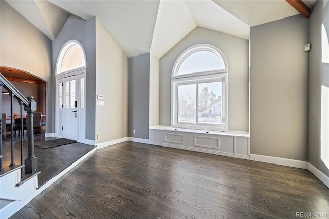 foyer with high vaulted ceiling and dark wood-type flooring