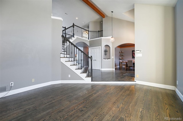 foyer with beam ceiling, high vaulted ceiling, and dark wood-type flooring