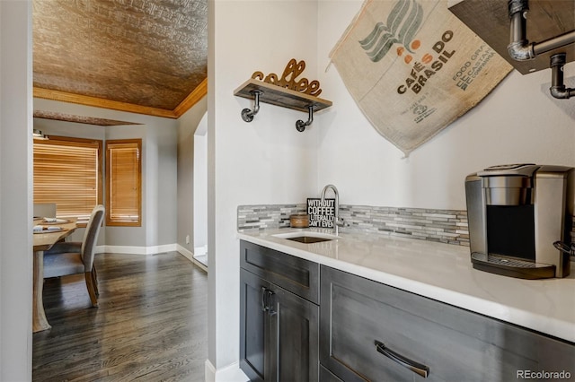 kitchen with decorative backsplash, dark hardwood / wood-style flooring, ornamental molding, and sink