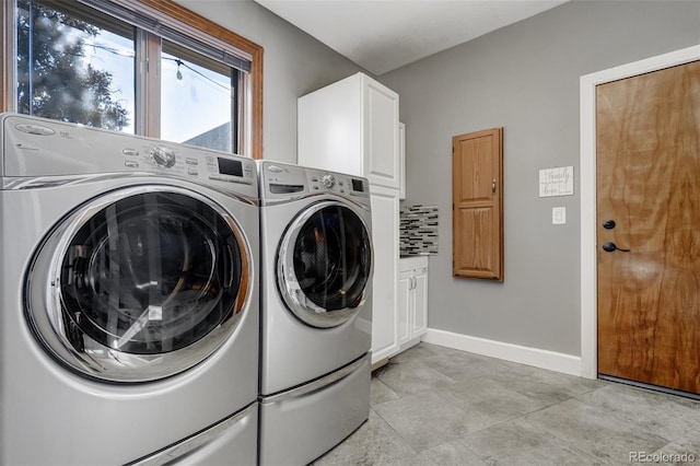 laundry room featuring washing machine and dryer and cabinets