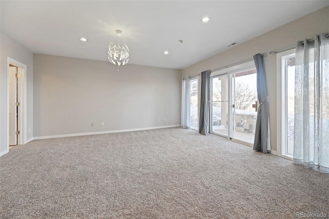 unfurnished room featuring carpet and an inviting chandelier