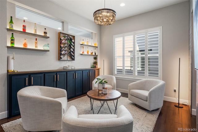 sitting room with indoor bar, baseboards, recessed lighting, a notable chandelier, and wood finished floors