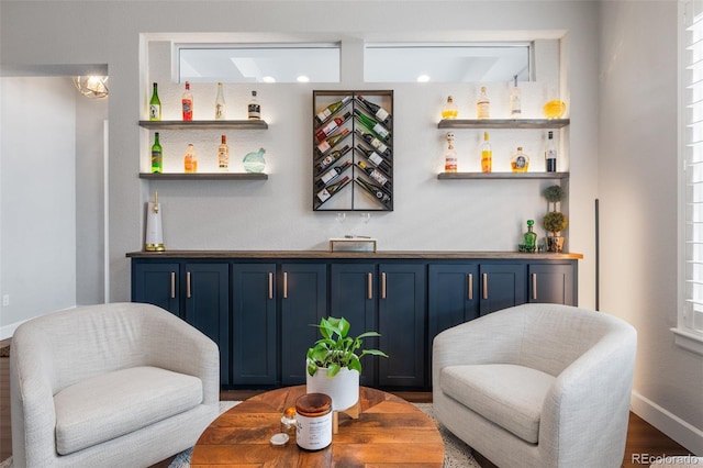 bar featuring wet bar, wood finished floors, and baseboards