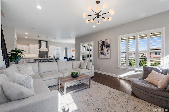 living area with recessed lighting, dark wood finished floors, baseboards, and an inviting chandelier