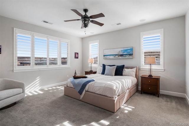 carpeted bedroom featuring baseboards, a ceiling fan, and visible vents