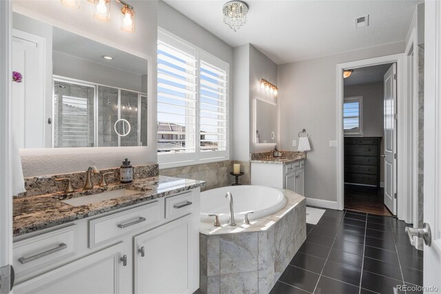 bathroom with a shower stall, visible vents, plenty of natural light, and a sink