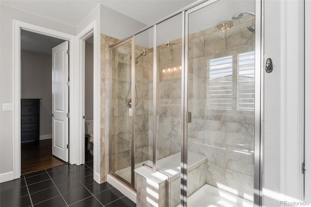 full bath with baseboards, tile patterned flooring, and a shower stall