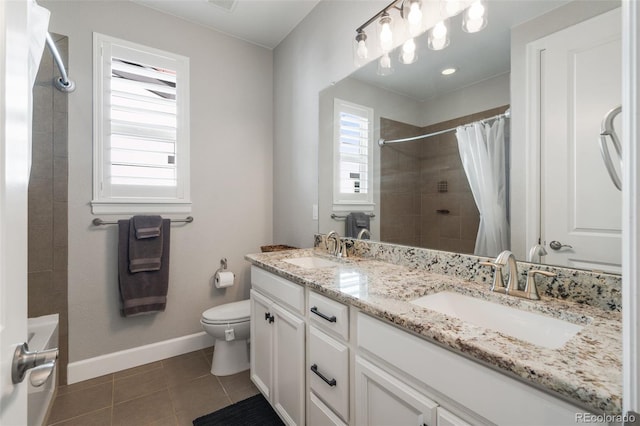 bathroom featuring tile patterned floors, toilet, baseboards, and a sink