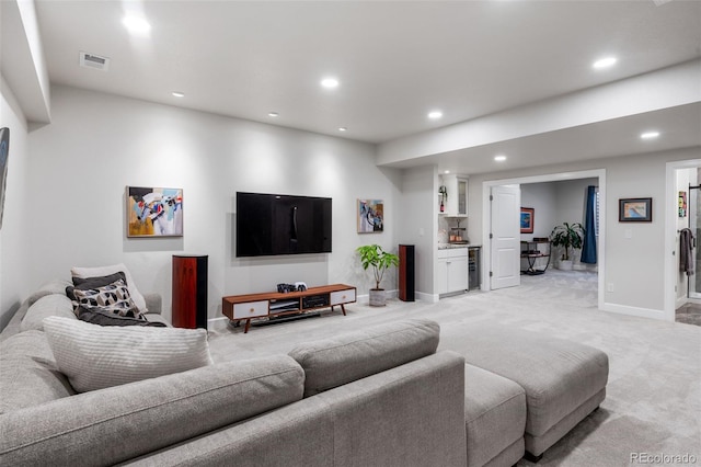 living area featuring baseboards, light carpet, indoor bar, and recessed lighting