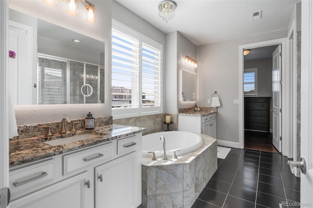 9724 Cantabria Pt, Lone Tree, CO 80124 - full bathroom featuring two vanities, healthy amount of natural light, a stall shower, and tile patterned floors