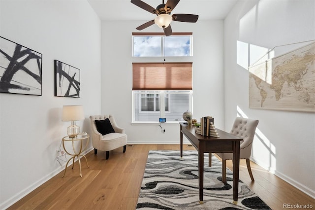 office space featuring ceiling fan, baseboards, and wood finished floors