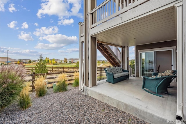 view of patio / terrace featuring fence and stairs