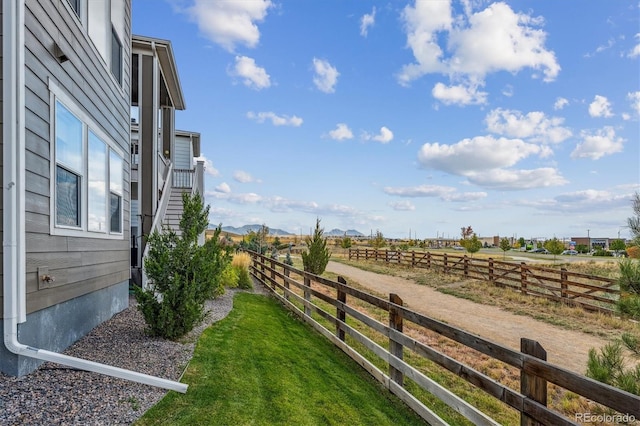 view of yard with a rural view and fence