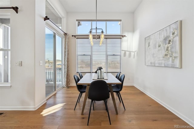 dining area with a chandelier, visible vents, baseboards, and wood finished floors