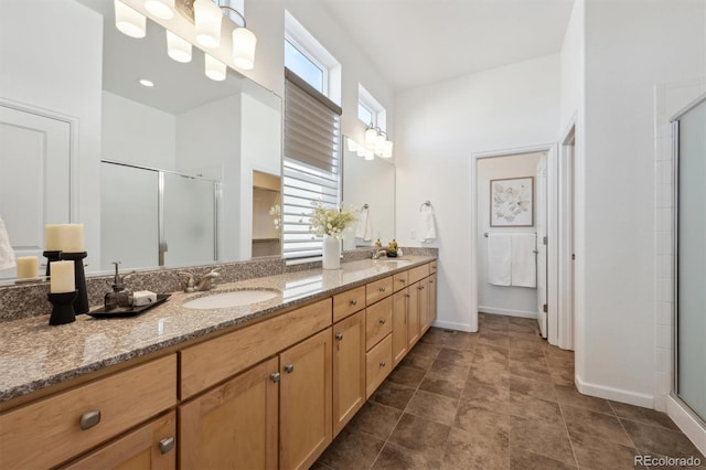 full bath with double vanity, a stall shower, and a sink