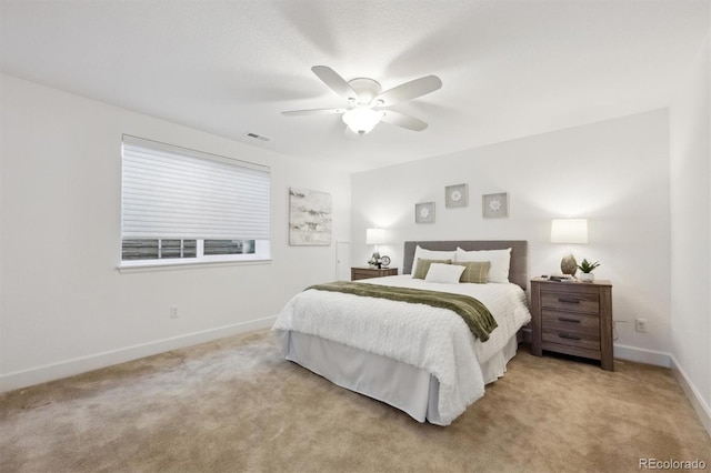 carpeted bedroom with visible vents, baseboards, and a ceiling fan