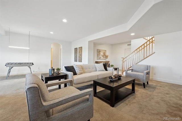 living room with arched walkways, light carpet, and recessed lighting