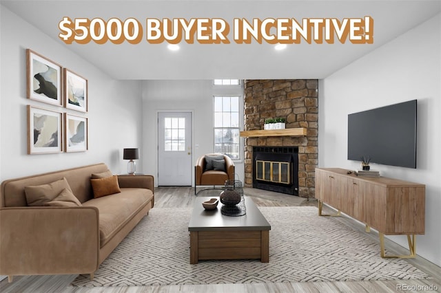 3281 S Estes St, Lakewood, CO 80227 - living area featuring light wood-type flooring and a stone fireplace