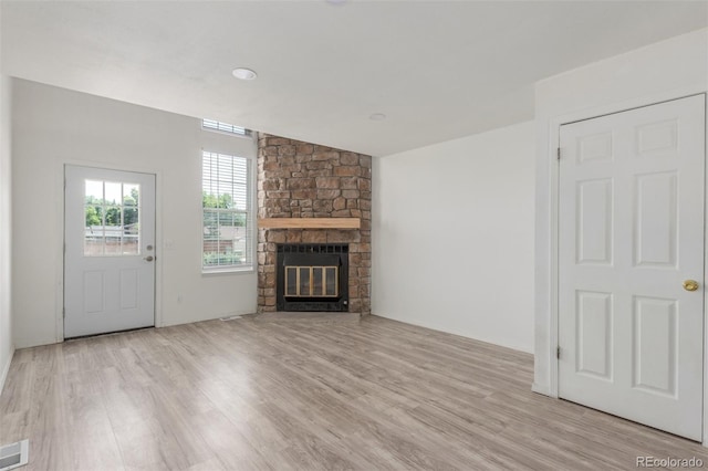 3281 S Estes St, Lakewood, CO 80227 - unfurnished living room with light wood-style floors and a stone fireplace
