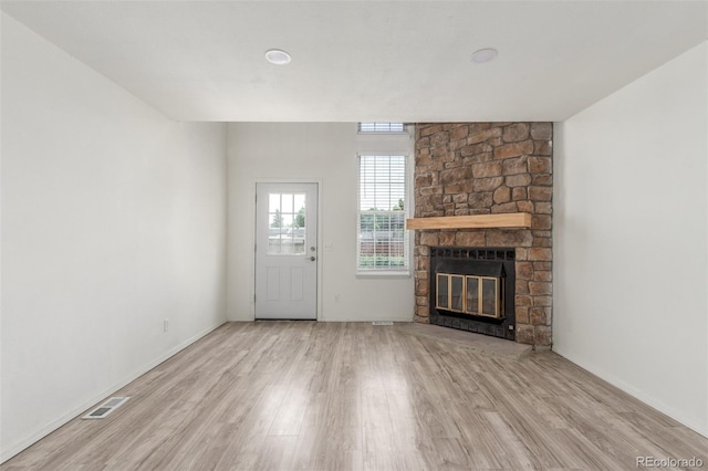 3281 S Estes St, Lakewood, CO 80227 - unfurnished living room with wood finished floors and a stone fireplace