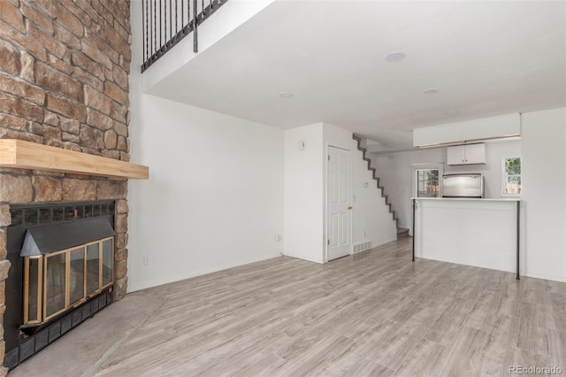3281 S Estes St, Lakewood, CO 80227 - unfurnished living room featuring stairway, light wood-type flooring, and a fireplace
