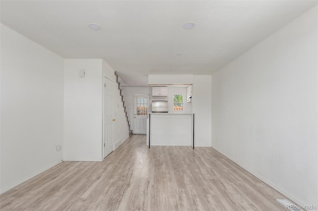 3281 S Estes St, Lakewood, CO 80227 - unfurnished living room with light wood-type flooring and stairway