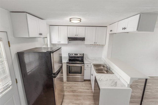 3281 S Estes St, Lakewood, CO 80227 - kitchen featuring stainless steel appliances, under cabinet range hood, light wood finished floors, a peninsula, and white cabinetry