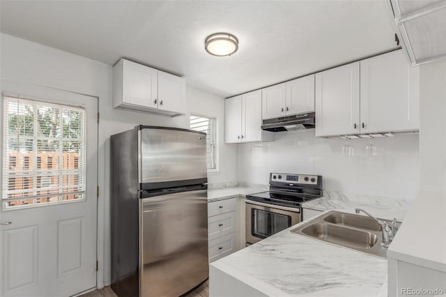 3281 S Estes St, Lakewood, CO 80227 - kitchen with appliances with stainless steel finishes, under cabinet range hood, plenty of natural light, and light countertops